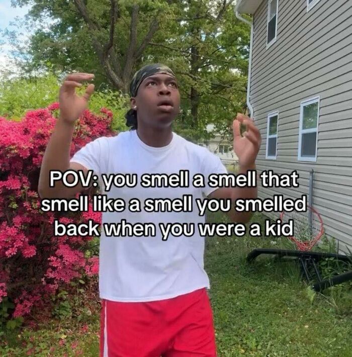 Young man reacting with surprise outdoors beside blooming flowers, illustrating a relatable meme about childhood smells.