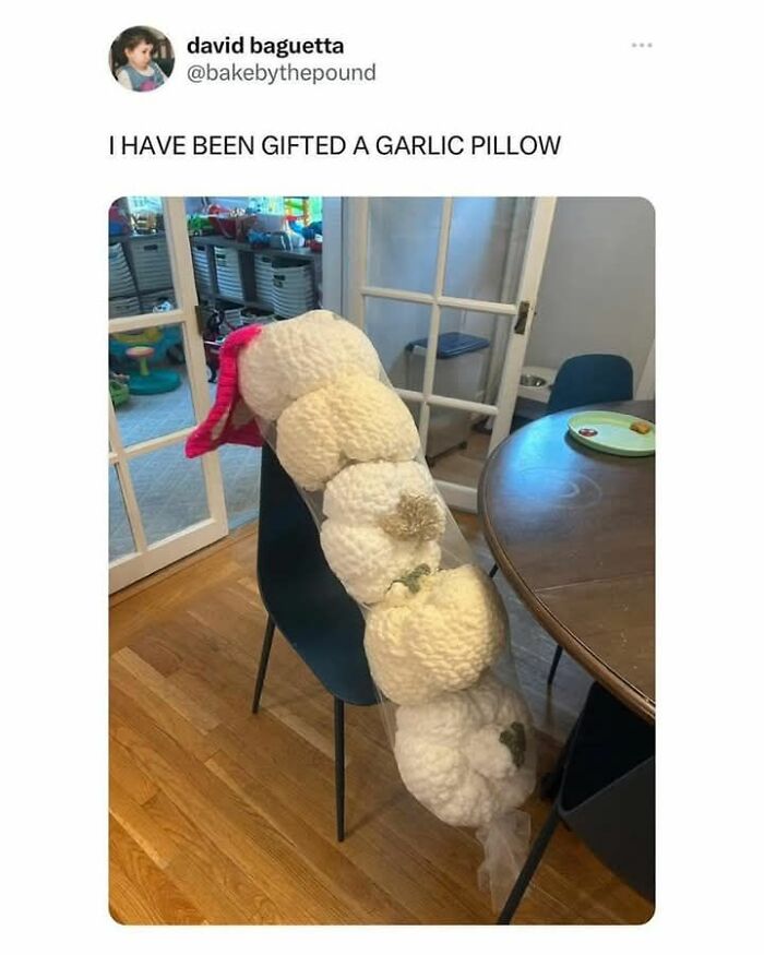 Crocheted garlic pillow draped over a chair in a home dining room, showcasing a humorous DIY craft project fail.