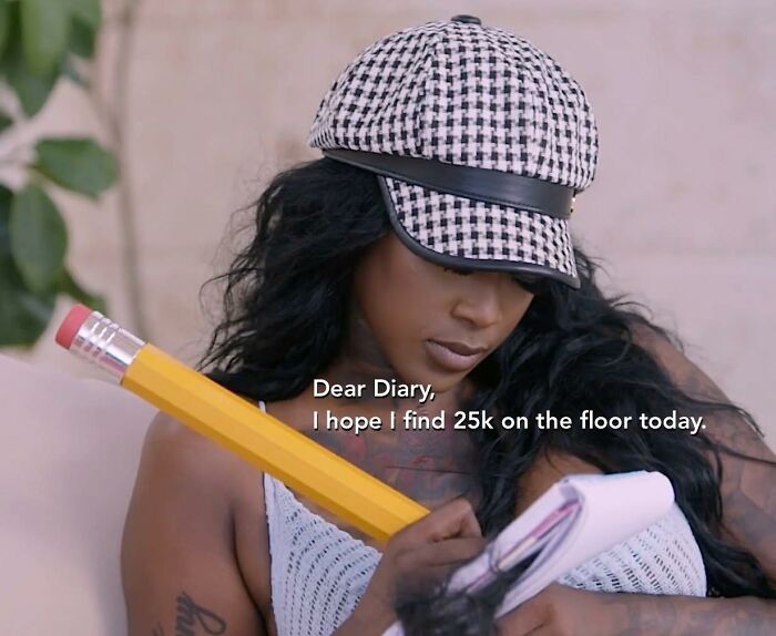 Woman wearing a houndstooth hat writing in a diary holding a large pencil, representing a Facebook group for non-millennials and non-Gen Z.
