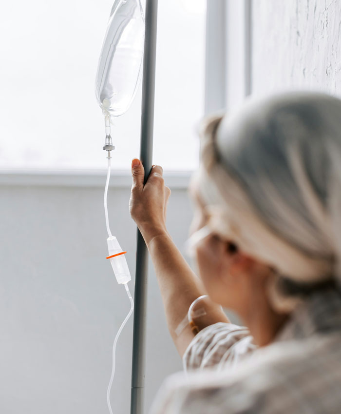 Patient holding intravenous drip pole in a hospital room, illustrating challenges in how I paid for college expenses.