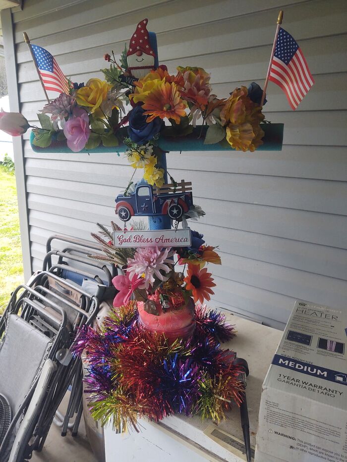 Patriotic craft project with artificial flowers, miniature flags, and decorative truck, showcasing a homemade DIY fail.