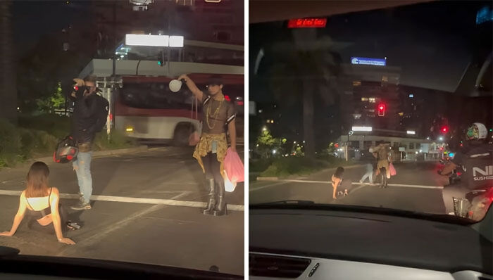 Three unhinged influencers causing chaos on a road at night for views, holding objects and blocking traffic dangerously.