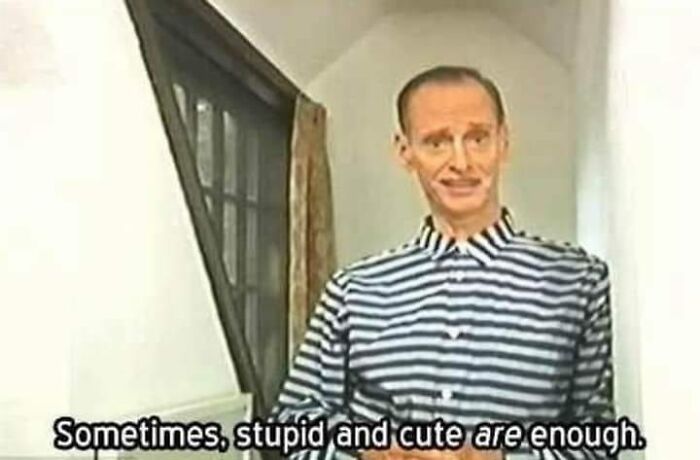 Man in striped shirt standing in narrow hallway with caption about memes being relatable and cute enough.