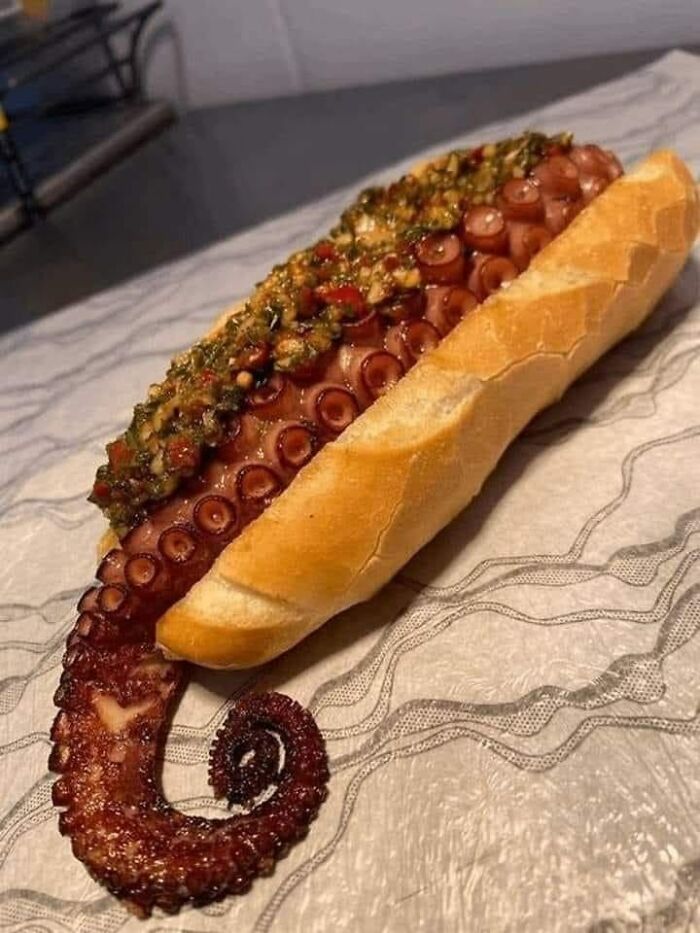 Octopus tentacle served in a sandwich bun with seasoning, a cursed picture of food that might make you go eeeeuw.
