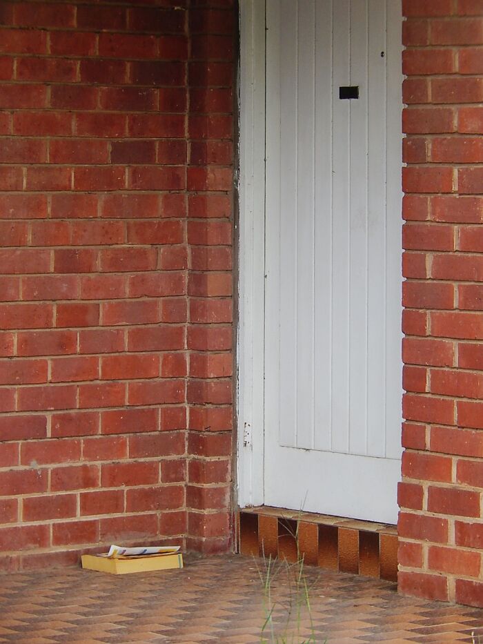 Paper delivery on a doorstep against a brick wall reflecting childhood joys not recorded before smartphones existed.