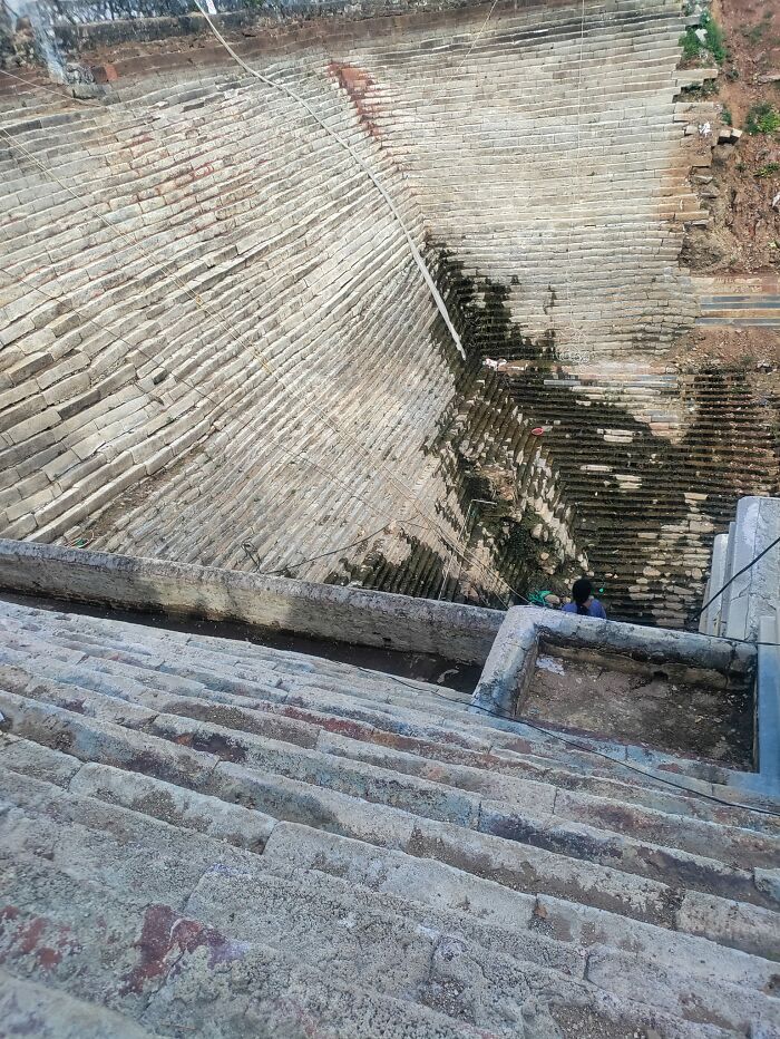 Steep and uneven death stairs forming a dangerous and challenging stone staircase with a person climbing at the bottom.