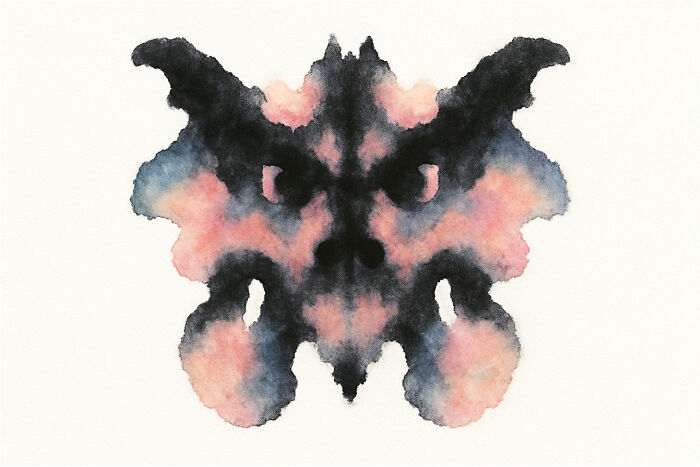 Rorschach inkblot showing symmetrical black and pink shapes resembling a face, used in an inkblot poll test.