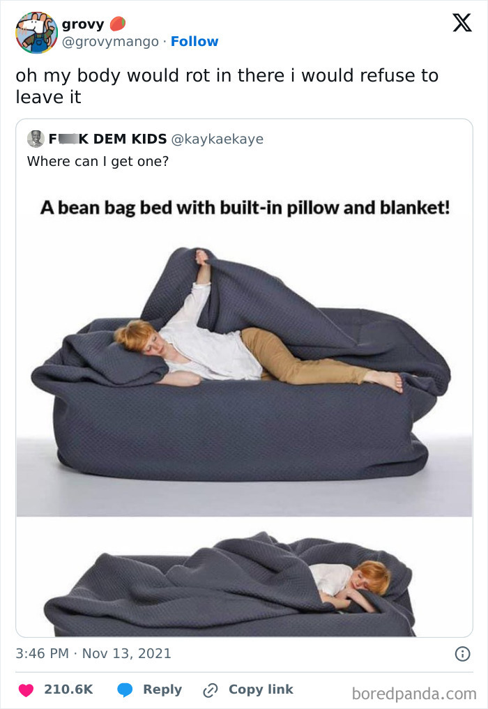 Person relaxing on a dark gray bean bag bed with built-in pillow and blanket, perfect for introvert everyday life.