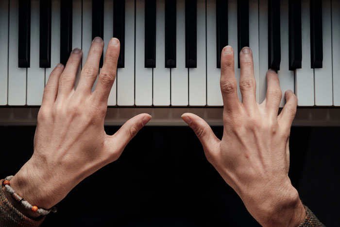 Hands positioned above piano keys, representing toxic dating trends people weirdly accept as normal in relationships.