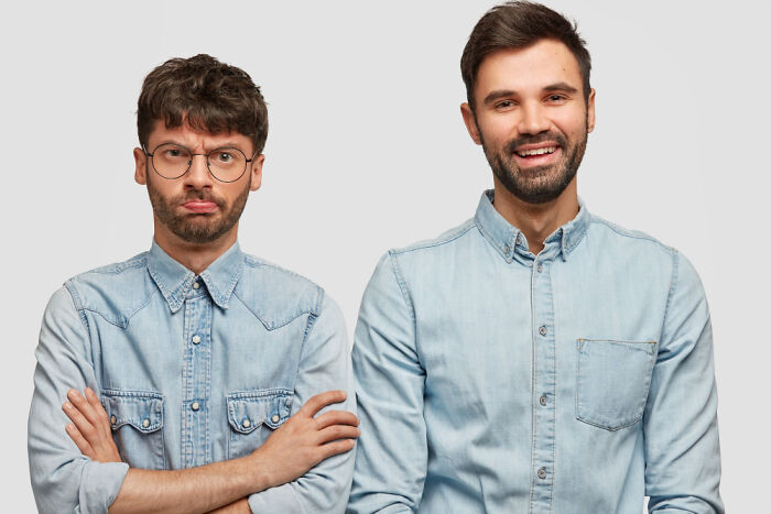 Two men in denim shirts, one serious and one smiling, representing parents and kids with deep secrets between them.