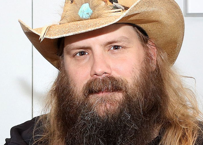 Bearded man wearing a cowboy hat and black shirt, representing celebrities before fame found them in a casual setting.