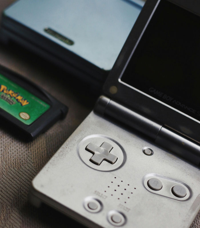 Close-up of a Game Boy Advance and a Pokemon game cartridge, illustrating creative ways to pay for college expenses.