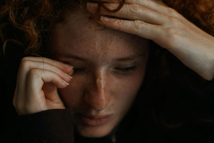 Young woman with red hair showing emotional distress, capturing the intensity of insane revelations people had in therapy.