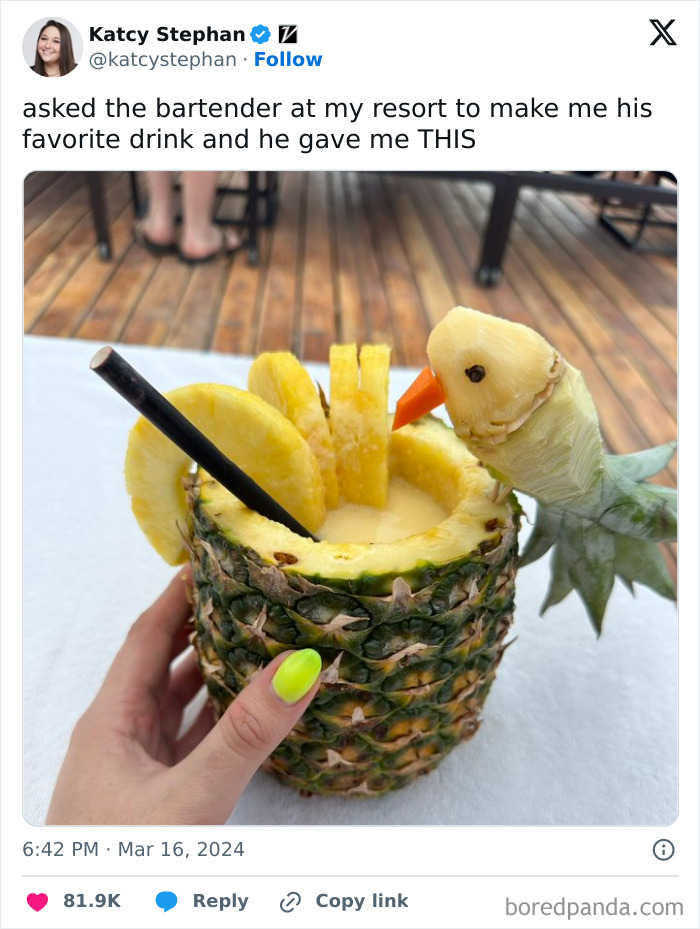 Hand holding a pineapple drink decorated with pineapple slices and a carved bird, fitting wholesome memes theme.