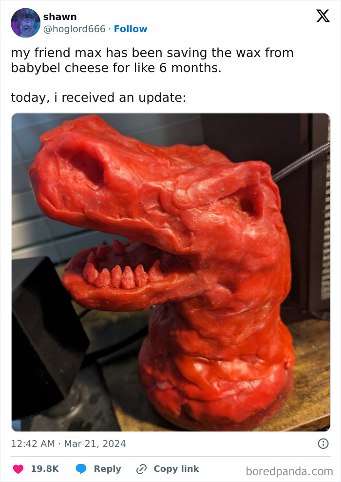 A grotesque red wax sculpture resembling a dinosaur head made from saved Babybel cheese wax over months.