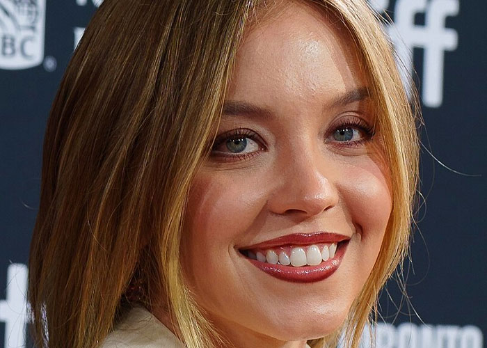 Close-up portrait of a smiling young woman, illustrating what celebrities were doing before fame found them.