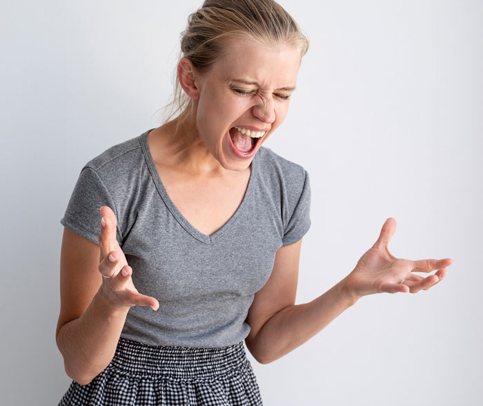 Frustrated woman yelling with hands raised, illustrating poor parenting and a mom risking custody over babysitting choices.