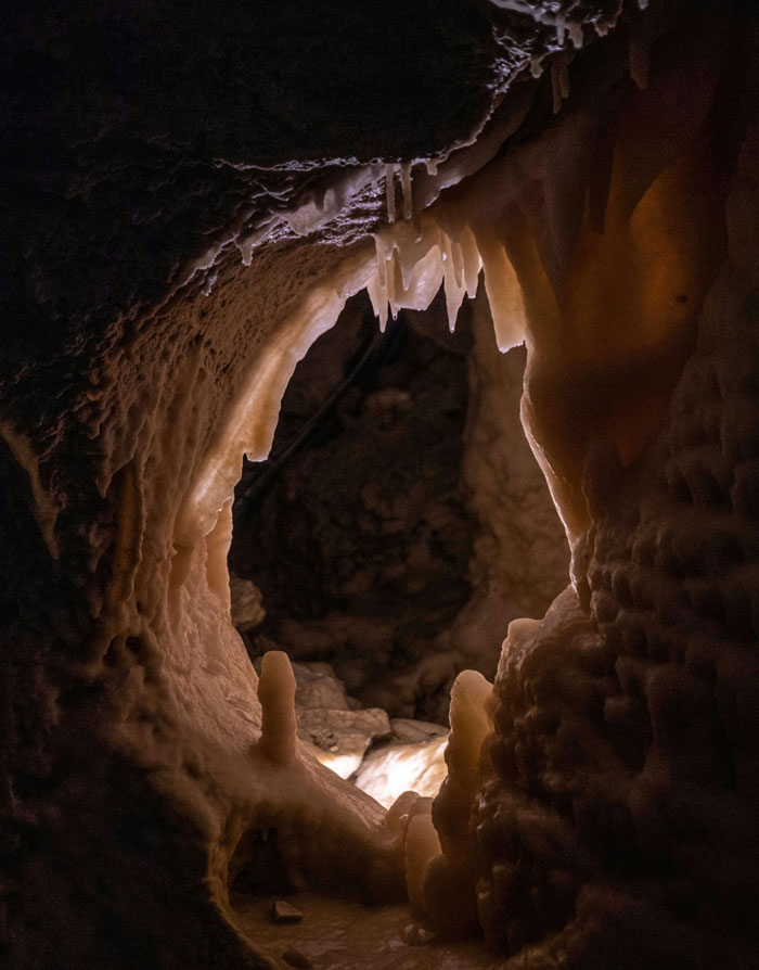 Dark cave interior with stalactites and stalagmites forming eerie shapes in one of the scariest places around the world.