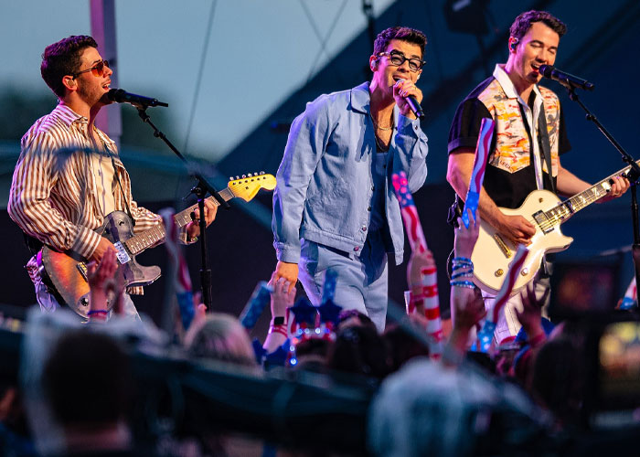 Band performing live on stage with guitars and microphone, showcasing what celebrities were doing before fame.