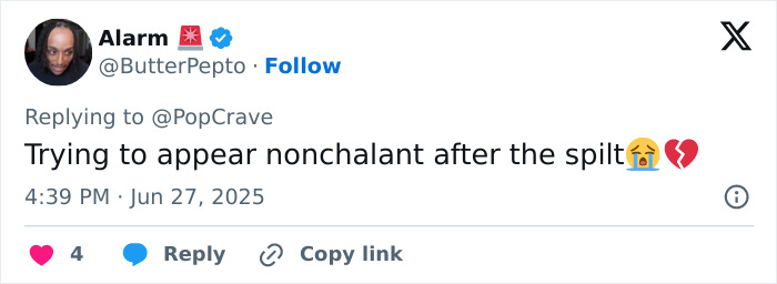 Tweet from user Alarm responding to PopCrave, expressing sadness after a breakup with crying and broken heart emojis.