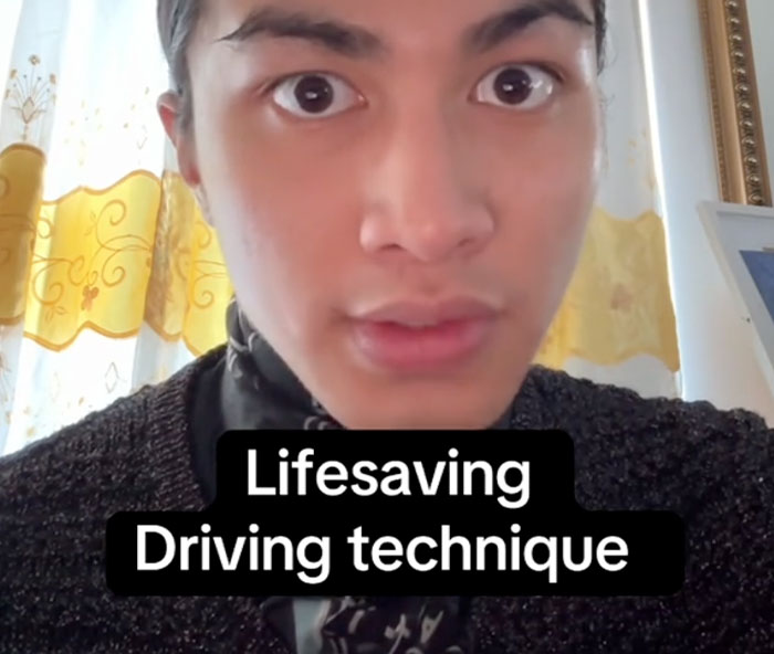 Young person explaining lifesaving driving technique in a home setting with yellow curtains and a framed photo in background.