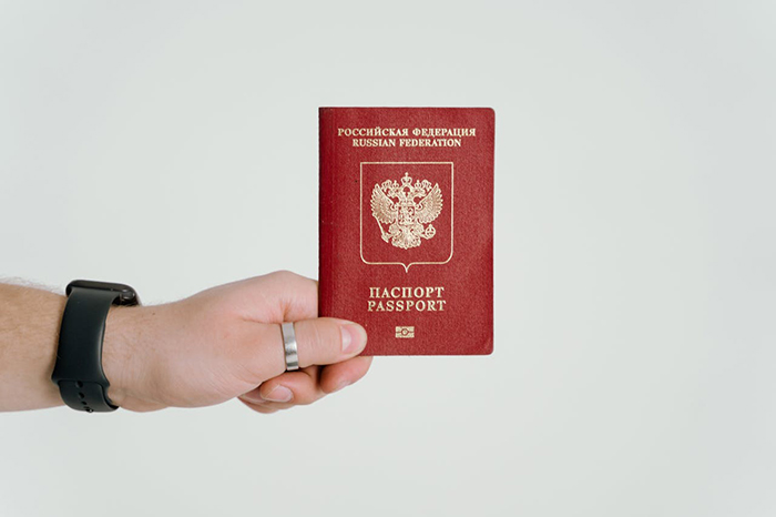 Hand holding a Russian passport, symbolizing a deadbeat ex&rsquo;s passport revoked and stranded in the airport.