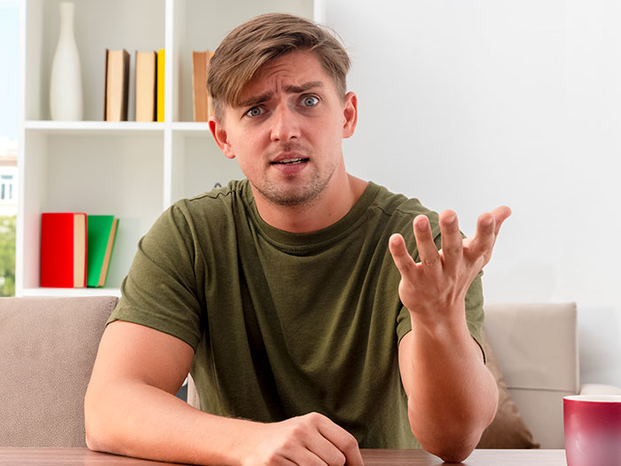Man in green shirt looking confused and concerned, reacting to bone broth added to meat-allergic woman&rsquo;s soup.