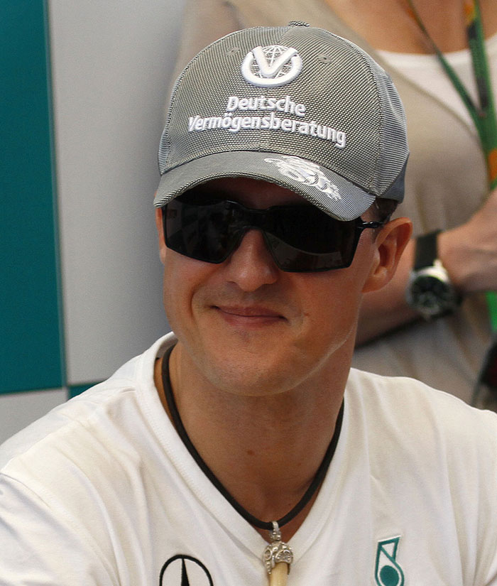Michael Schumacher wearing a cap and sunglasses, with an emotional update on his F1 health from his former boss.