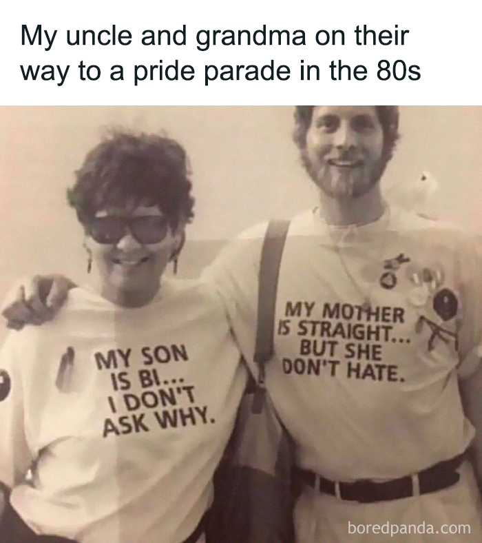 Two people wearing supportive pride T-shirts, smiling and embracing, showcasing wholesome feel-good moments and faith in humanity.