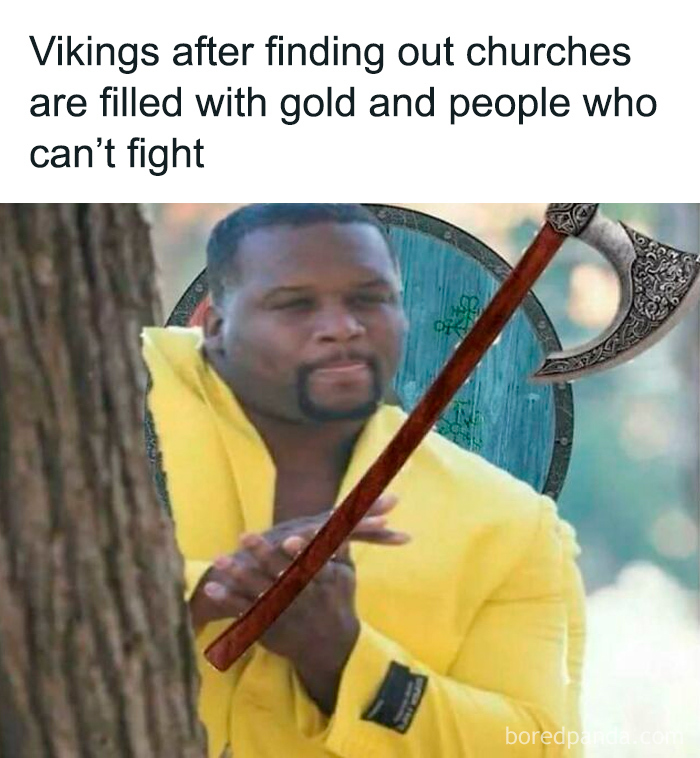 Man in yellow jacket rubbing hands next to tree with Viking axe and shield, illustrating history memes about Vikings and the past.