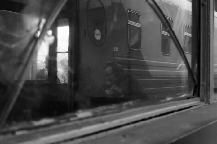 Black and white photo of a person reflecting inside an old train, symbolizing regret and biggest mistake in life moments.