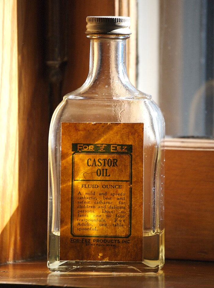 Vintage castor oil bottle sitting in sunlight, illustrating effective old wives' tales remedies and traditional health tips.