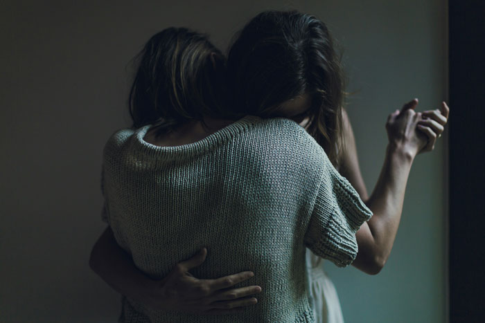 Two people embracing closely in a dimly lit room illustrating toxic dating trends in relationships.