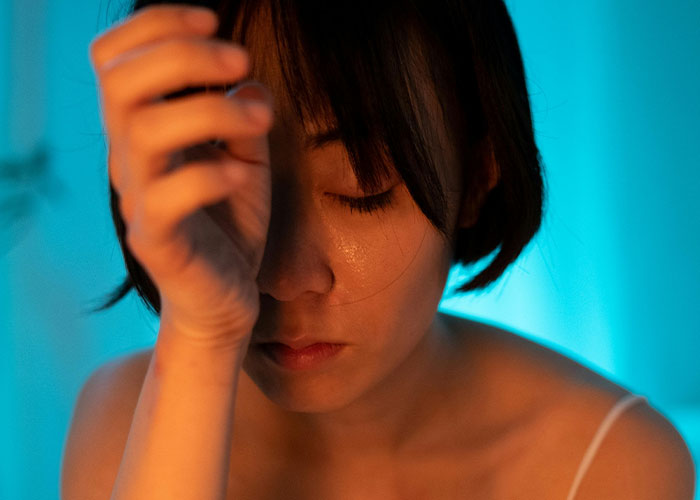 Young woman looking distressed and emotional, reflecting on painful reasons for called off engagements and relationship betrayal.