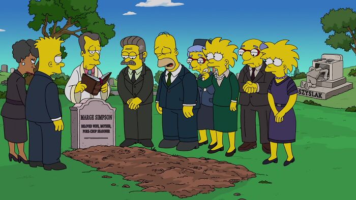 The Simpsons characters mourning at Marge&rsquo;s grave, highlighting animated character deaths in a graveyard setting.