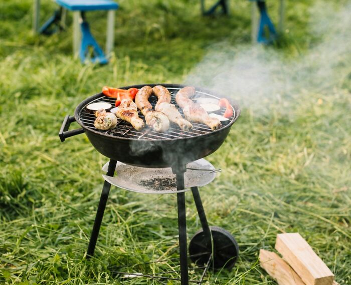 Outdoor barbecue grill in the UK with sausages and vegetables cooking, reflecting honest thoughts about the UK culture.