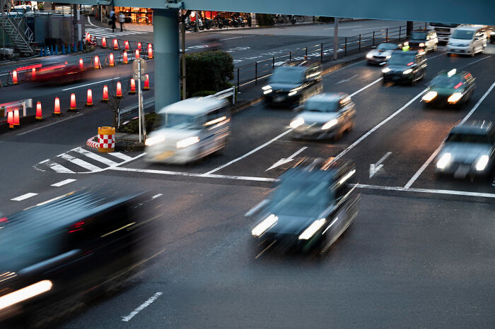 Busy urban road with fast-moving cars at dusk, illustrating the dynamic and honest perspectives on the UK.