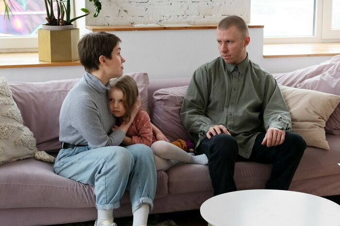 A tense family moment on a couch showing signs that reveal childhood struggles and emotional challenges.