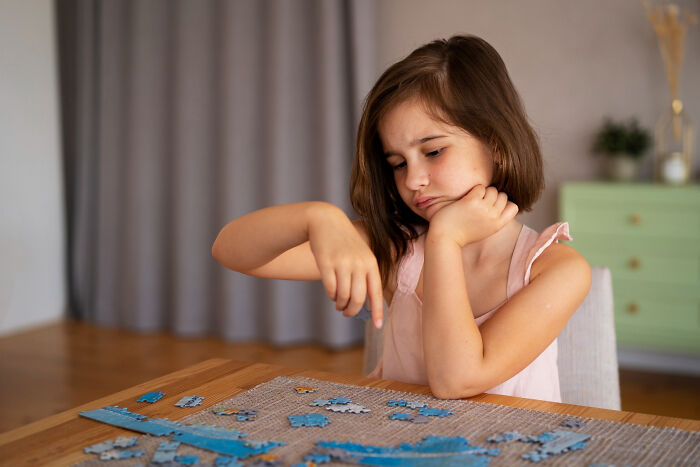 Young girl working on a puzzle at home, showing focus and determination, reflecting a completely legal total psychopath theme.