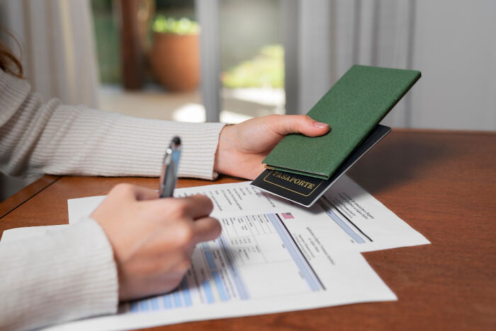Person holding a passport and filling out travel documents, demonstrating useful golden travel hacks for easy trip planning.