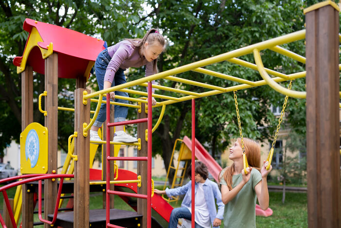 Children playing on a playground with climbing frames and swings, enjoying a good trend before it slowly disappeared.