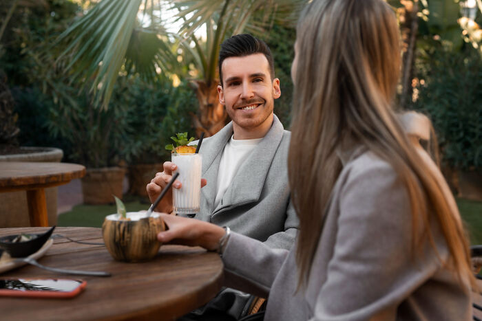 A man and woman at a bar having drinks, illustrating a date that went sour requiring a safe word intervention.