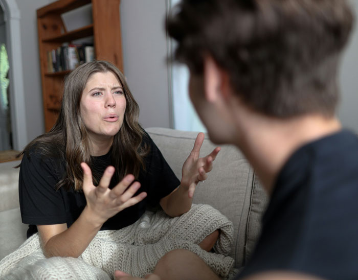 Young woman expressing frustration during a heated conversation with partner, illustrating toxic dating trends in relationships.