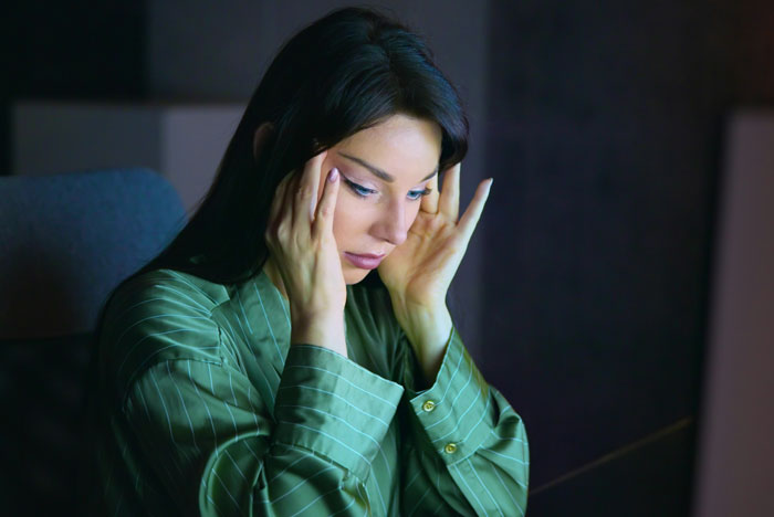 Woman in green shirt with stressed expression having intense revelations during therapy session at night