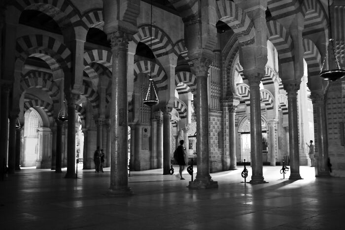 Interior of a historic building with striped arches and columns, showcasing breathtaking travel architecture captured by the community.