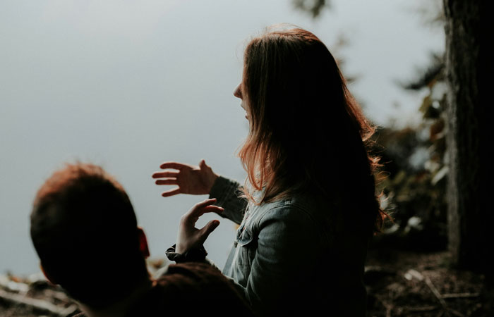 Two people involved in a serious conversation outdoors, highlighting toxic dating trends in relationships.