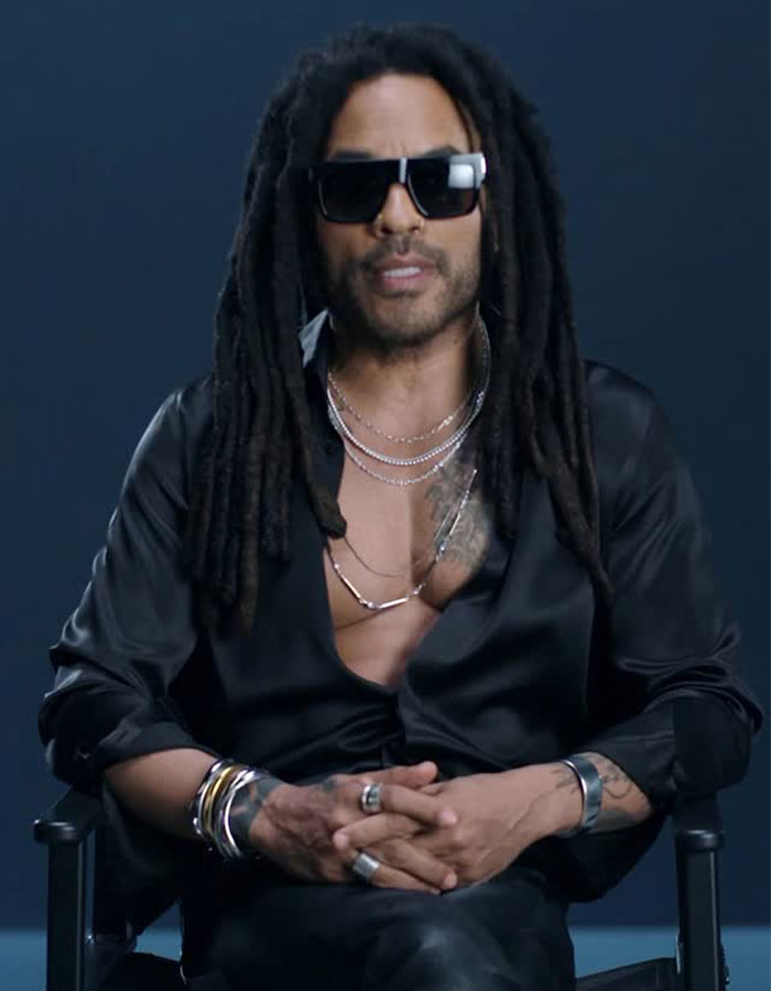 Man with long dreadlocks and sunglasses wearing a black shirt and multiple necklaces, representing celebrities who look younger
