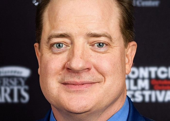 Close-up of a smiling male celebrity at a film festival, highlighting what celebrities were doing before fame found them.