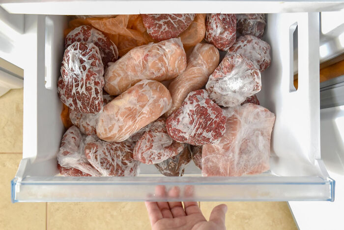 Frozen meat stored loosely in a freezer drawer, illustrating poor people habits still done by grossly rich netizens.