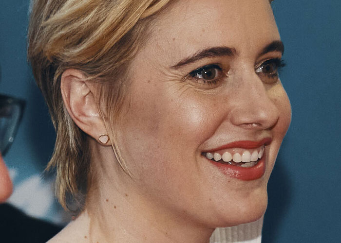 Close-up of a smiling celebrity with short blonde hair, showcasing what celebrities were doing before fame found them.